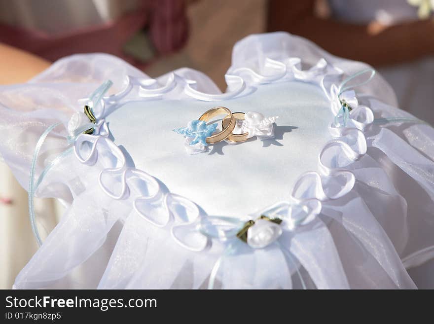 Wedding rings on a heart shaped pad. Wedding rings on a heart shaped pad