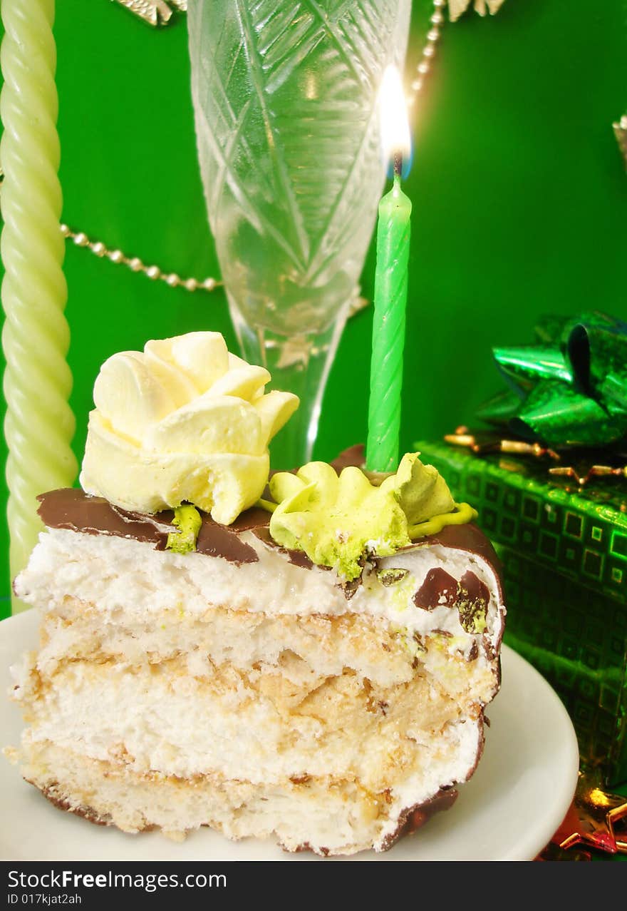 Celebratory table (cake and candles, glass with champagne, gift box)