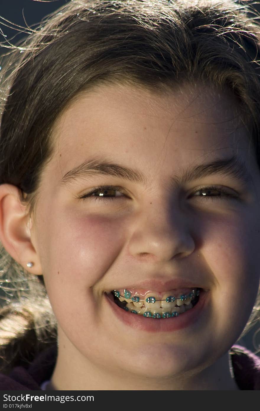 Headshot of girl smiling while wearing braces. Headshot of girl smiling while wearing braces