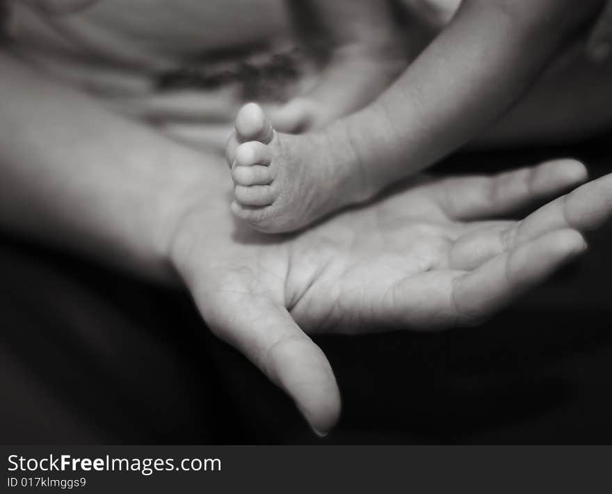 A new mother holding her child's feet. A new mother holding her child's feet.