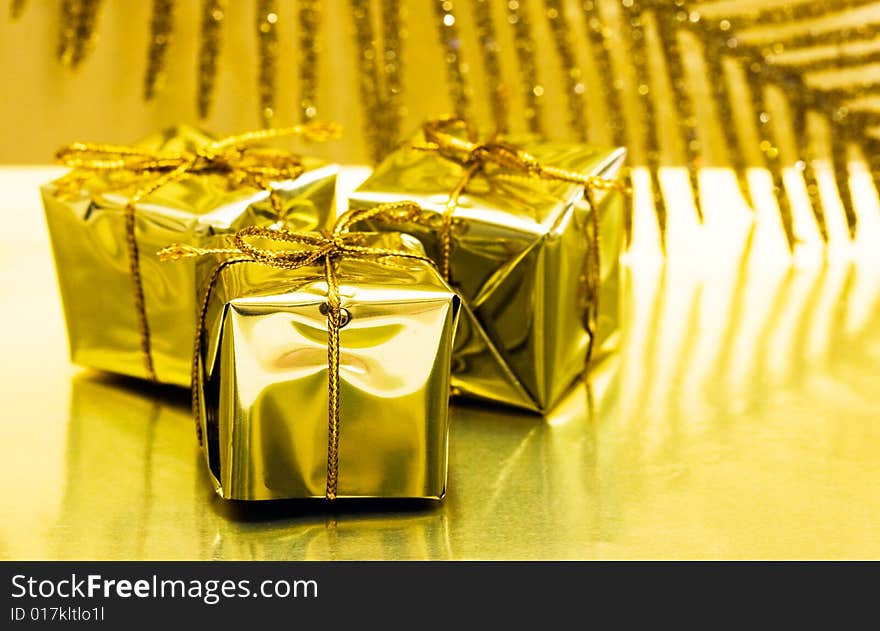 Gift boxes on golden background with leaf