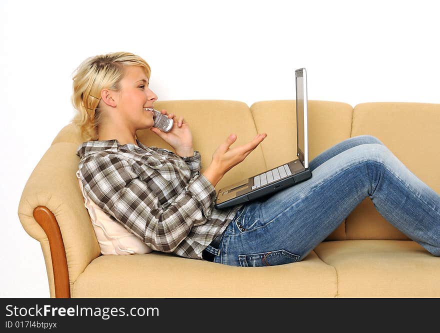 Young woman working with her laptop, sitting on a sofa. Young woman working with her laptop, sitting on a sofa.