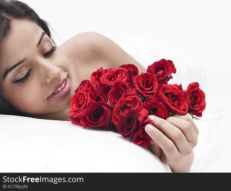 Asian female in bed with bunch of red roses. Asian female in bed with bunch of red roses