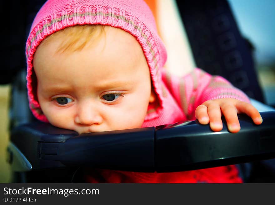 Serious Baby of 6 months outside on the  walk in the stroller. Serious Baby of 6 months outside on the  walk in the stroller