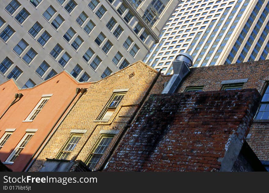 Skyscrapers rise behind historic buildings in the Warehouse District of downtown New Orleans, juxtaposing new and old. Skyscrapers rise behind historic buildings in the Warehouse District of downtown New Orleans, juxtaposing new and old.