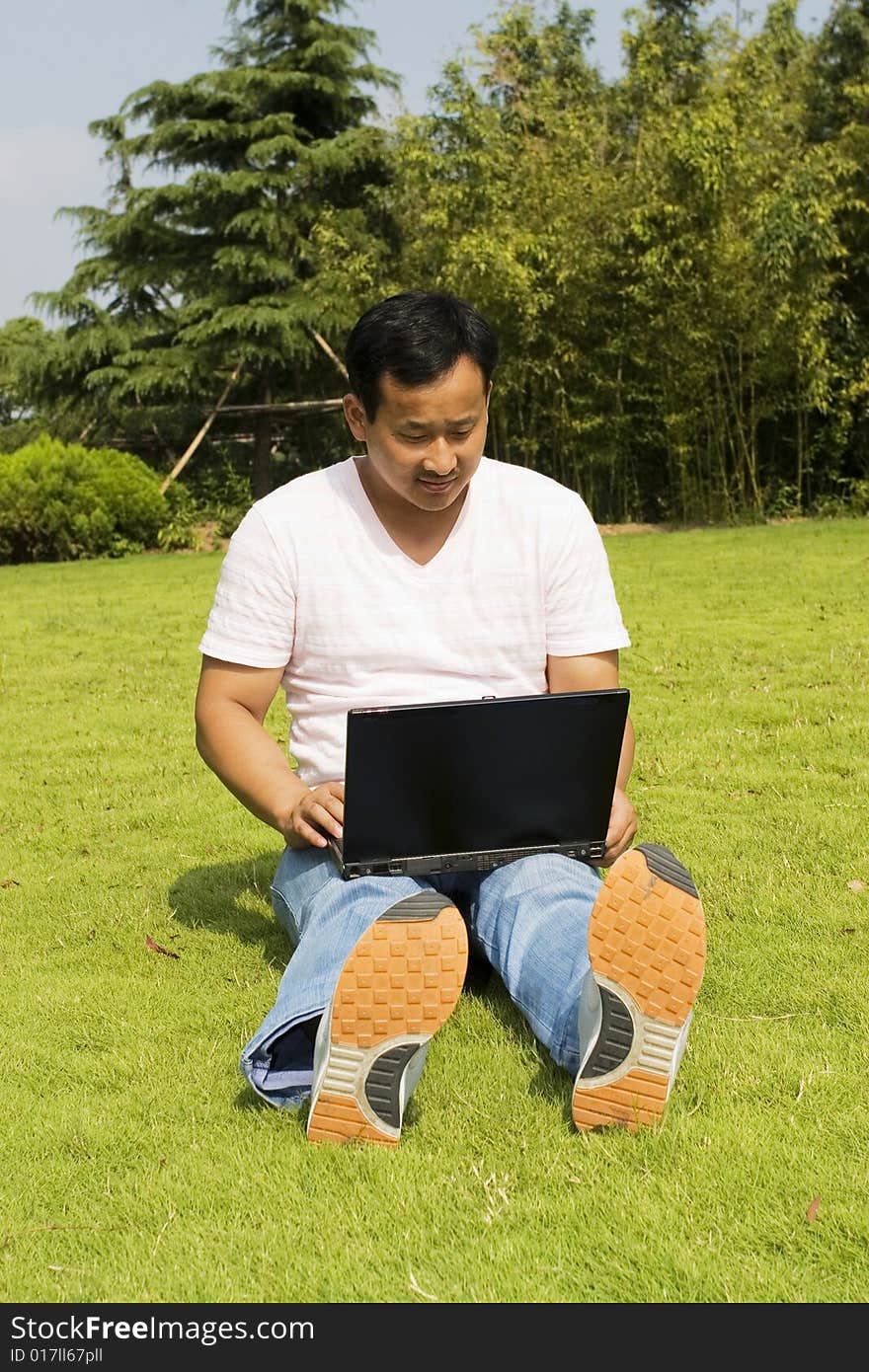 A young man using a laptop outdoors