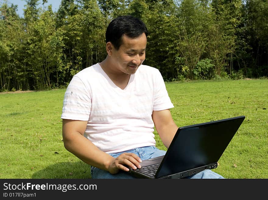 A young man using a laptop outdoors