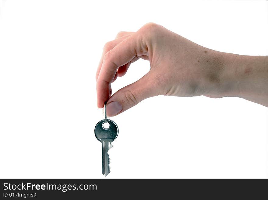 An isolated image of one key hanging from a hand. An isolated image of one key hanging from a hand