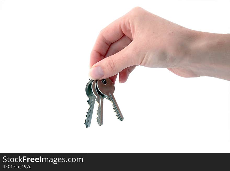 An isolated image of three keys hanging from a hand. An isolated image of three keys hanging from a hand