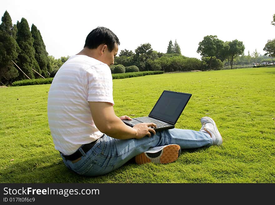 A young man using a laptop outdoors