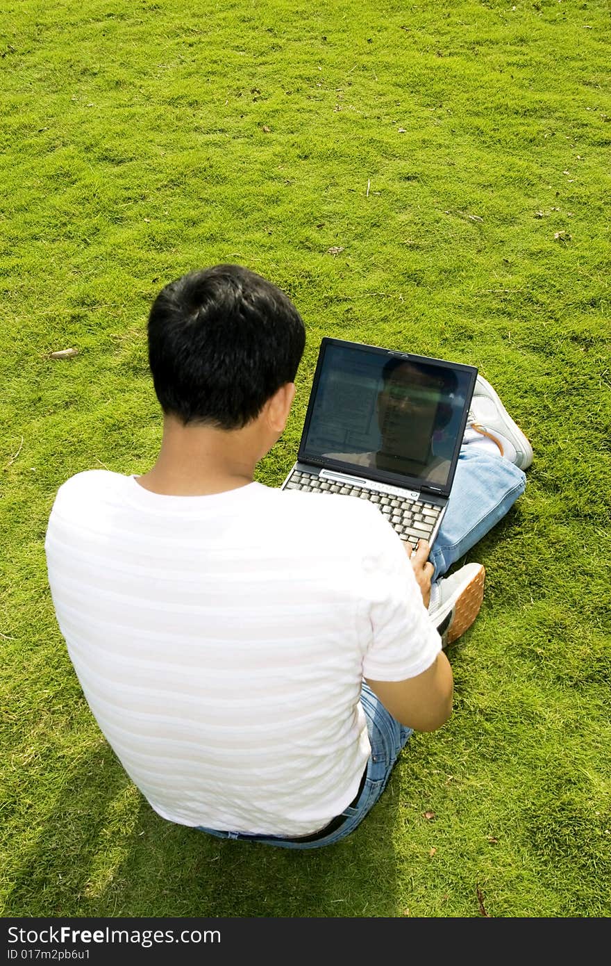 A young man using a laptop outdoors