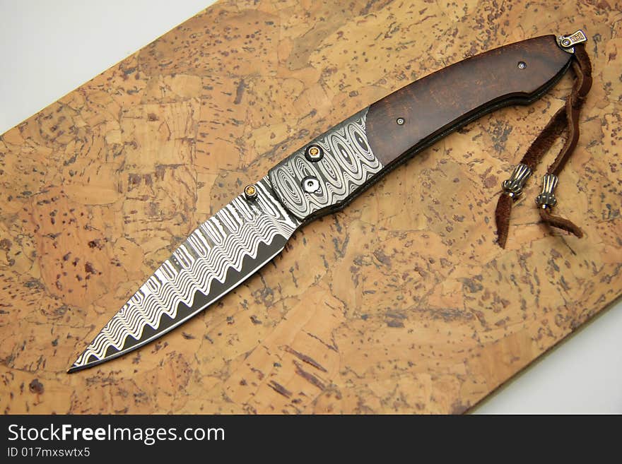 Stainless steel pocket knife isolated on the wood background