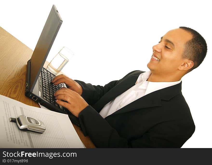 Isolated on white shot of happy business man typing on his laptop with office desk setting