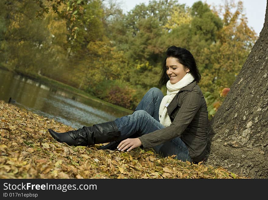 Happy female sitting on the lake with leaves. Happy female sitting on the lake with leaves