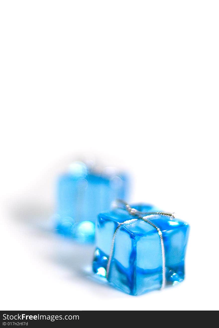 Two blue glass cubes with silver ribbon on white background