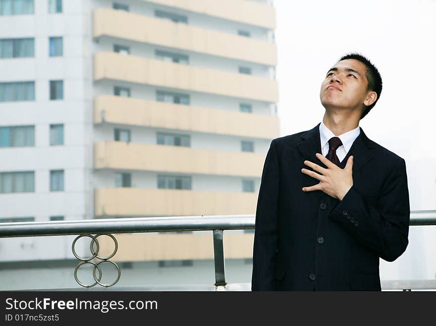 A young asian standing before building. A young asian standing before building