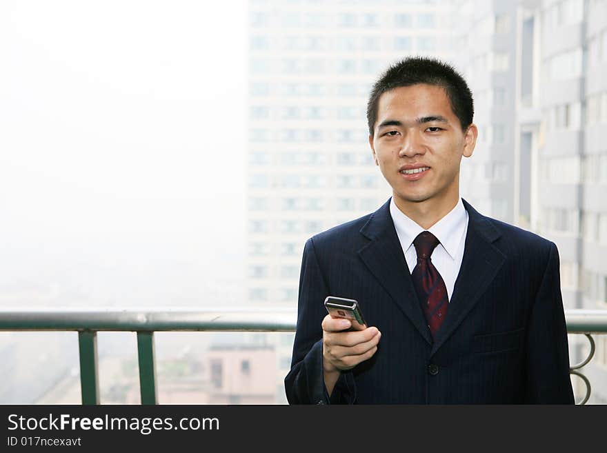 Young asian business man holding mobile phone