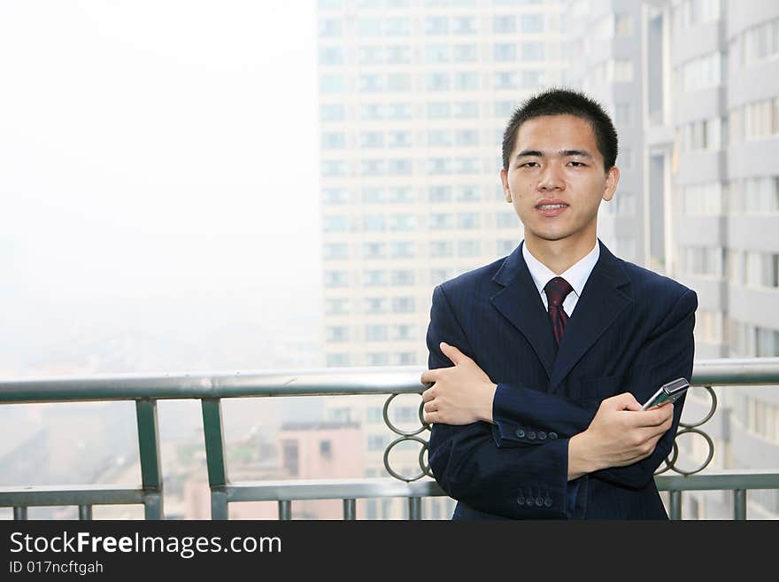 Young asian business man holding mobile phone