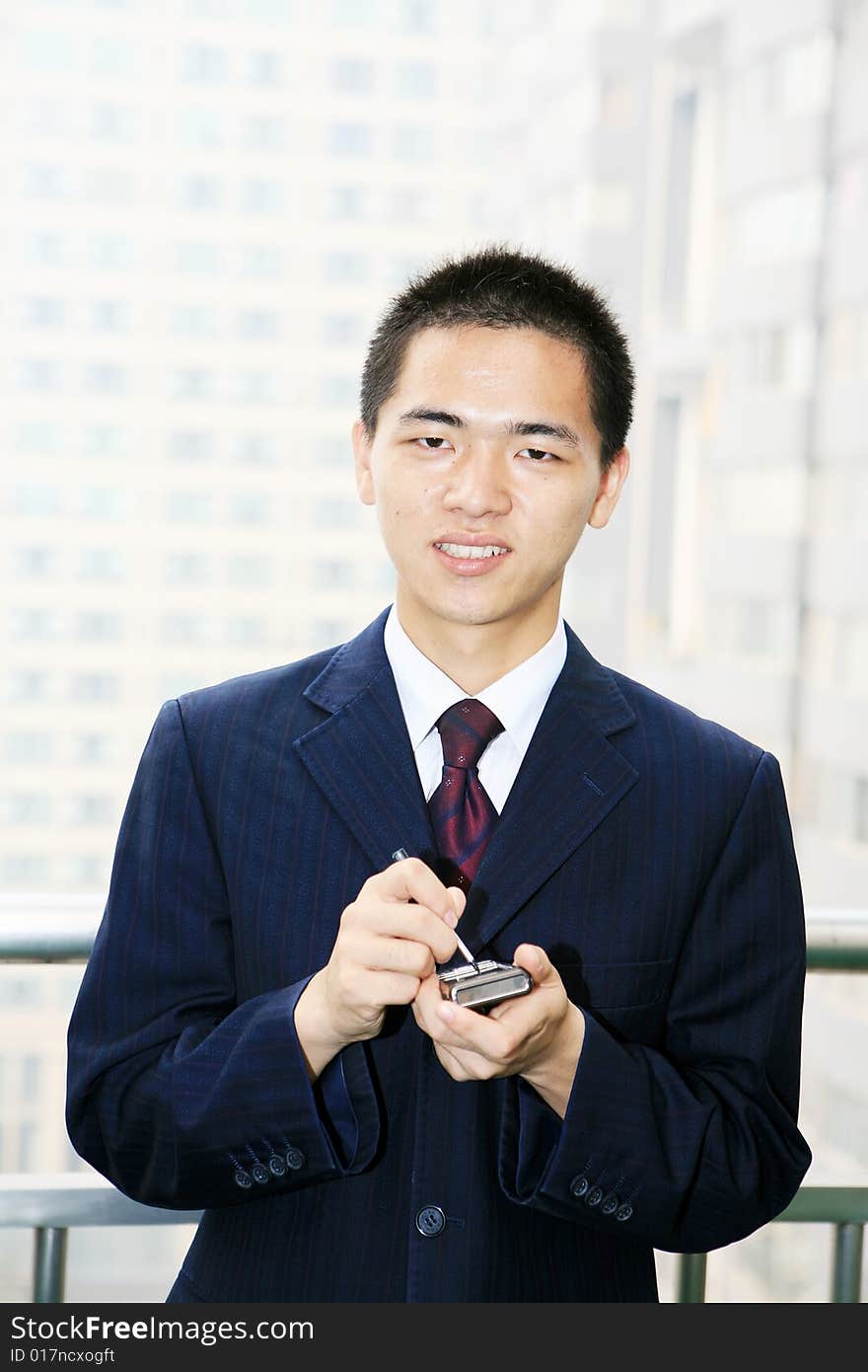 Young business man holding mobile phone