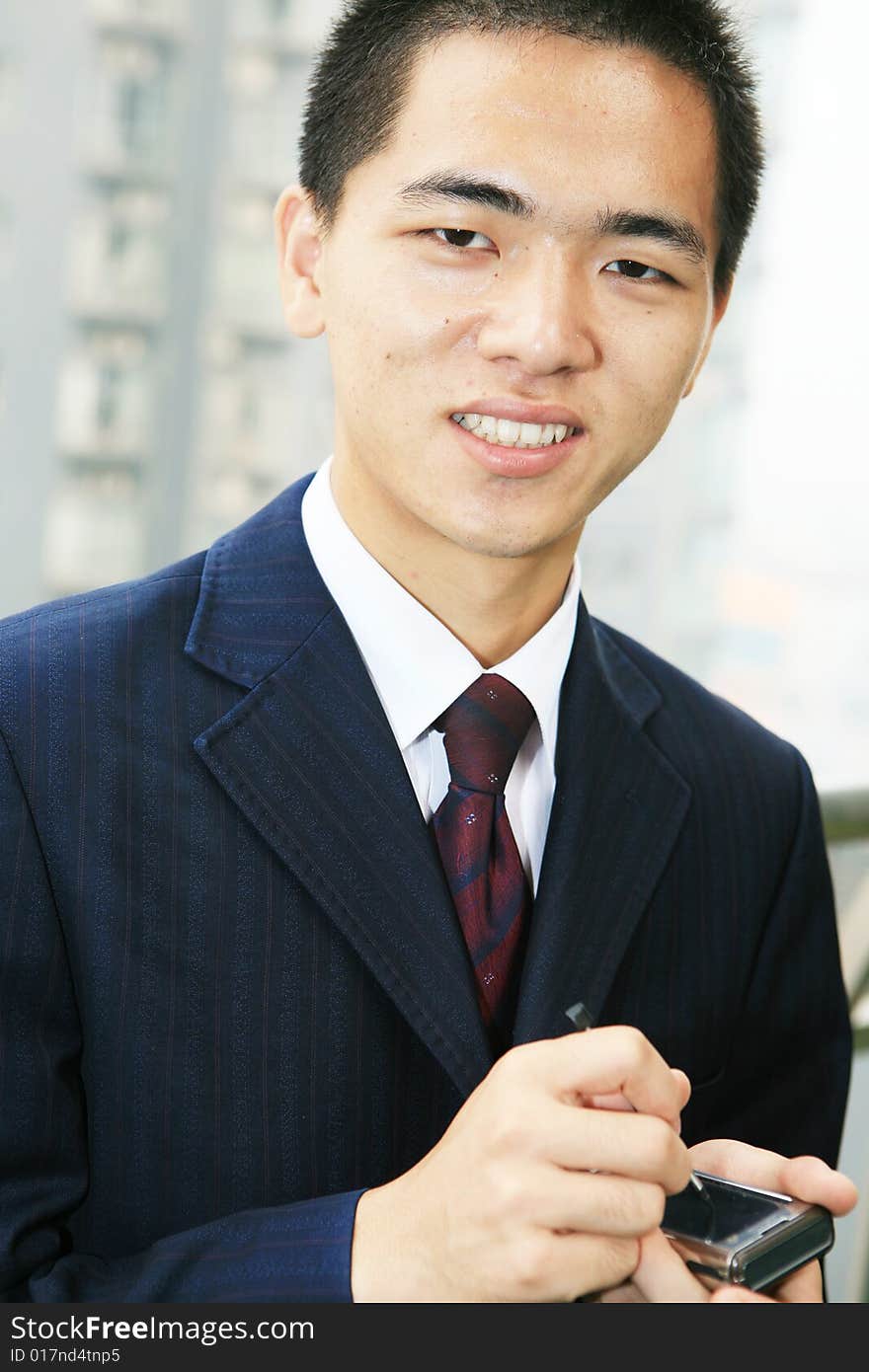 Young asian business man holding mobile phone