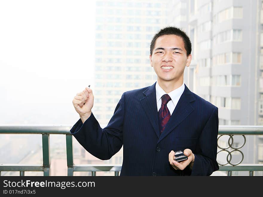 Young business man holding mobile phone