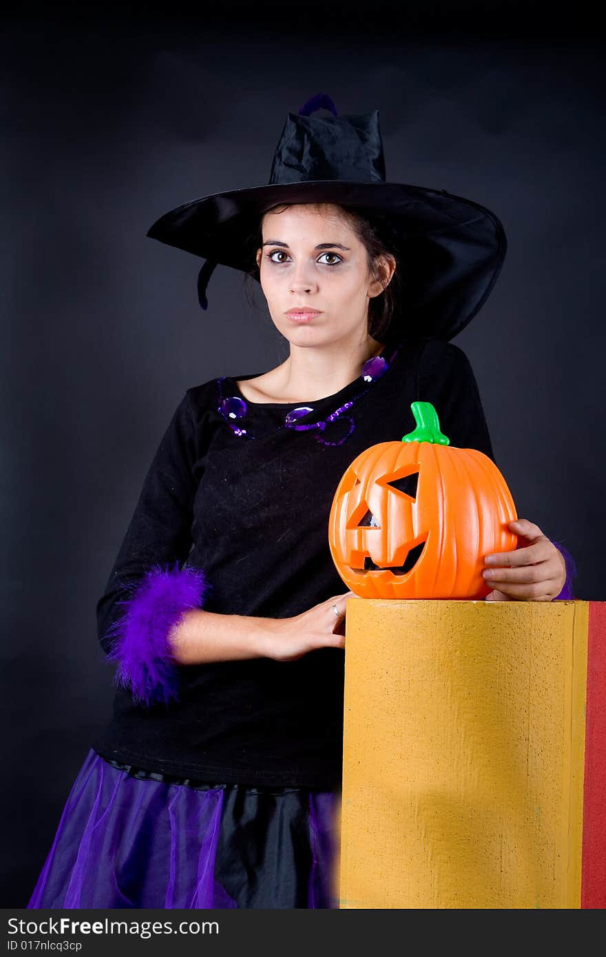 Young halloween witch with pumpink