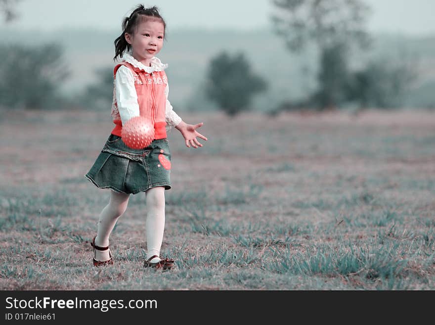 The girl playing ball outside.