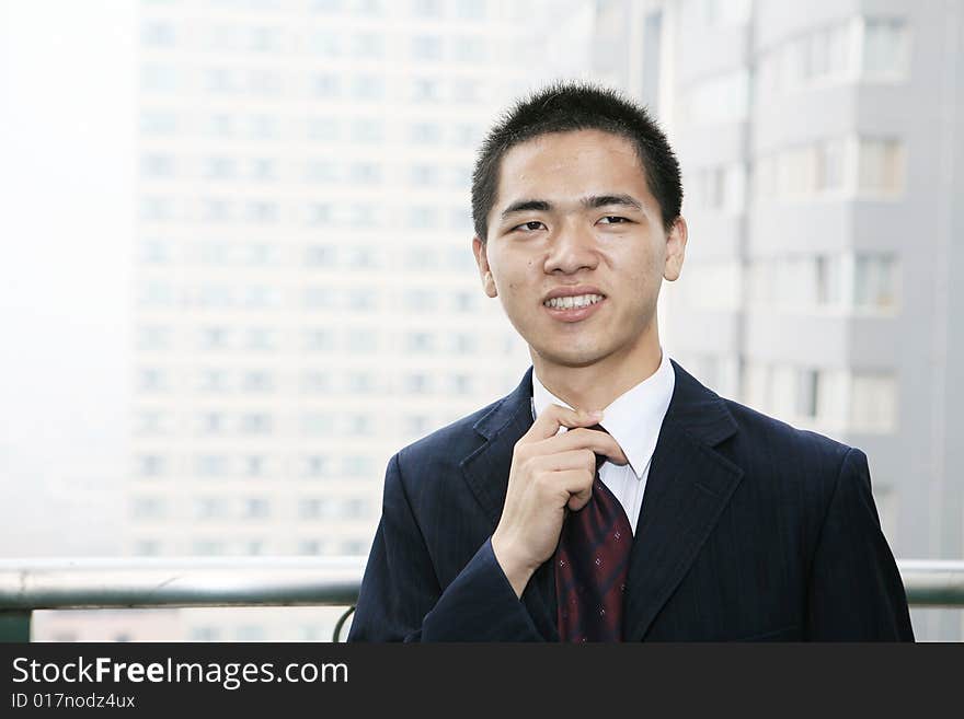 A young asian standing before building. A young asian standing before building