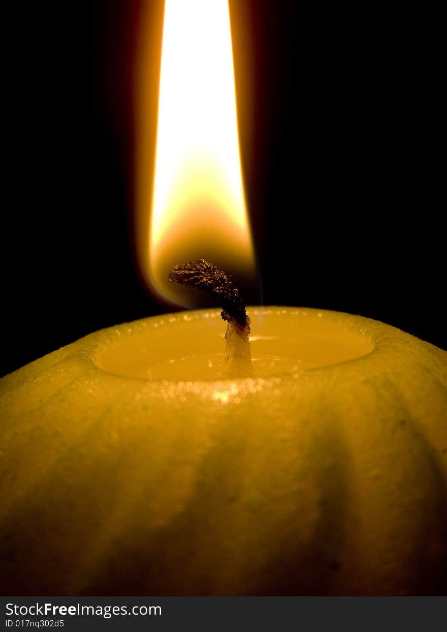 Candle with flame on black background