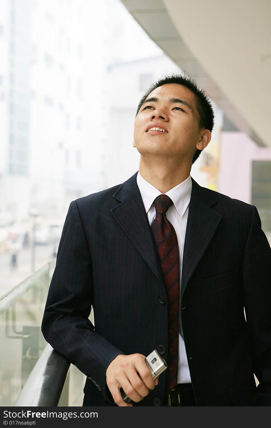 Young asian business man holding mobile phone