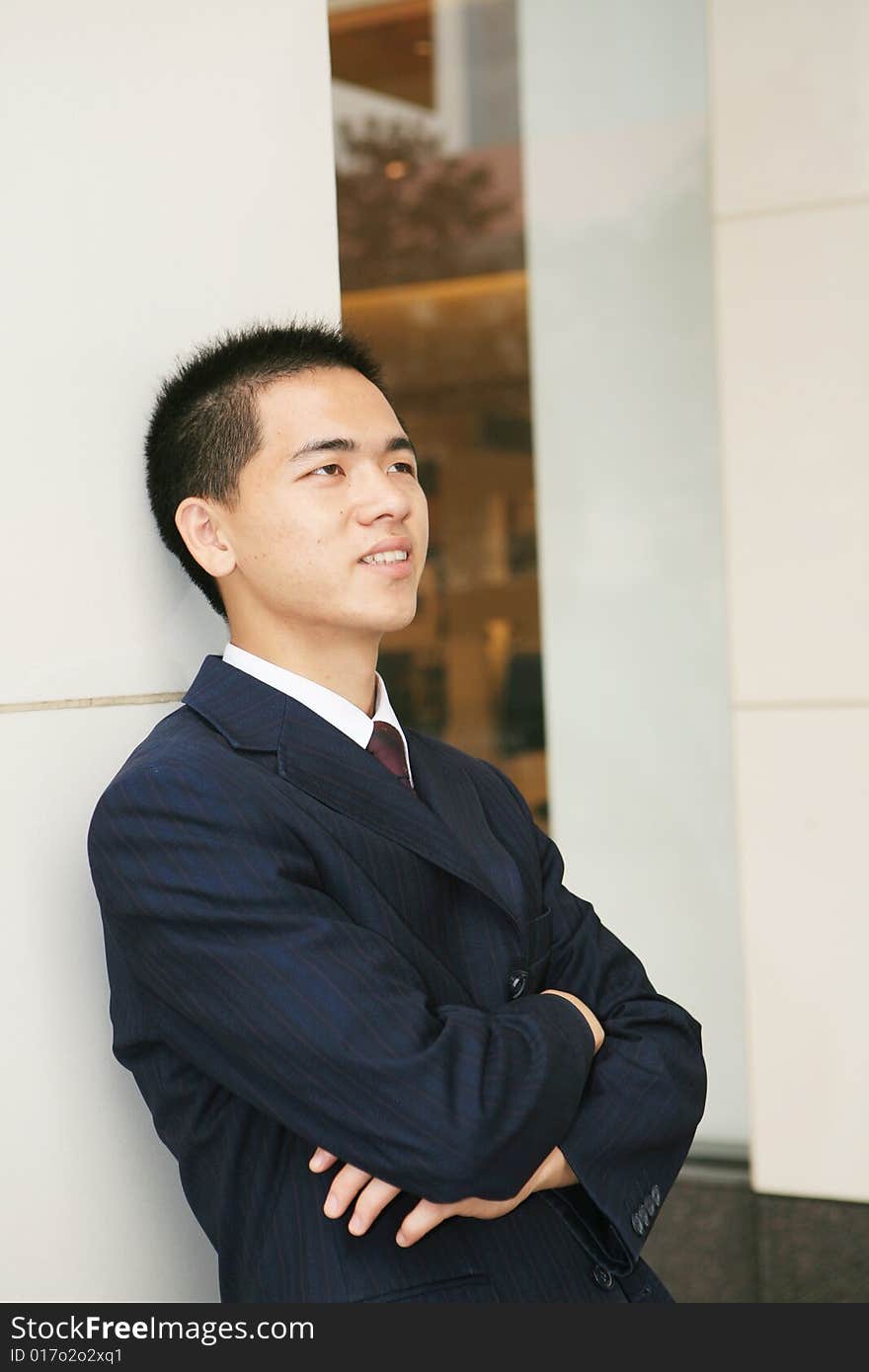 A young asian standing in office building. A young asian standing in office building