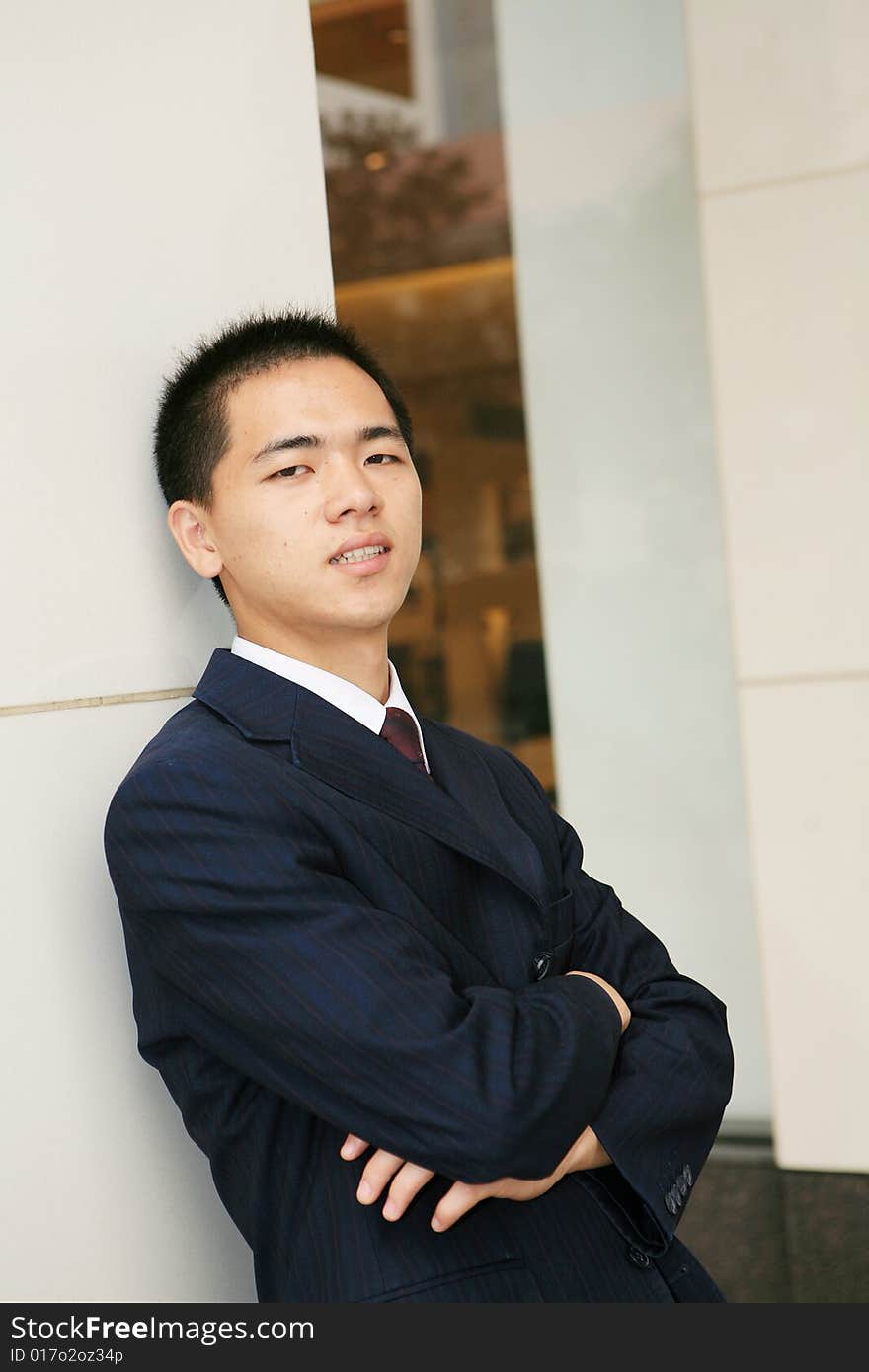 A young asian standing in office building. A young asian standing in office building