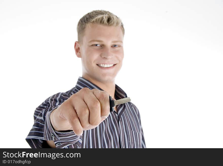 Smiling handsome man holding key on an isolated white background