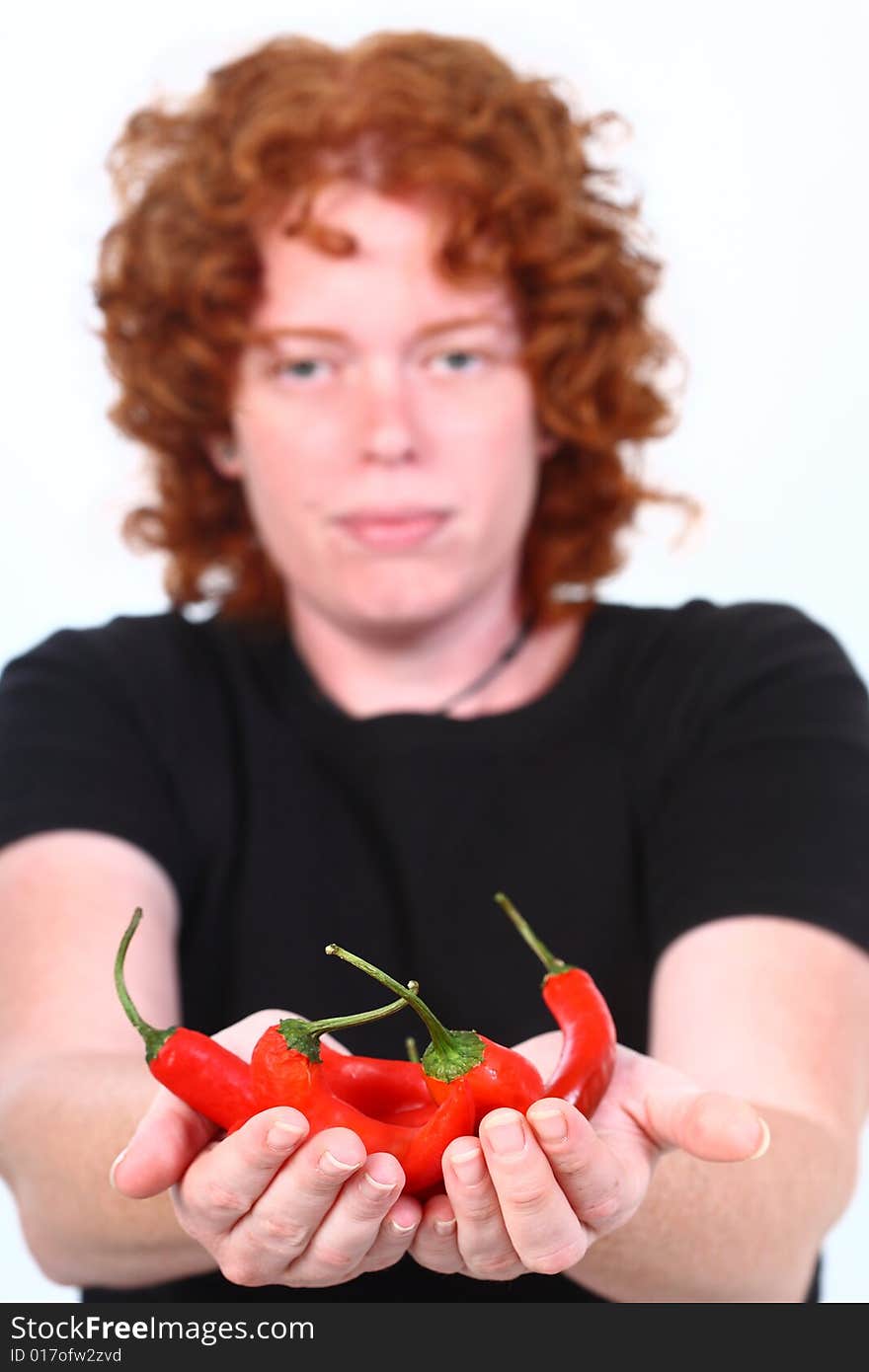 Red head woman holding stack of red chilli peppers. Red head woman holding stack of red chilli peppers