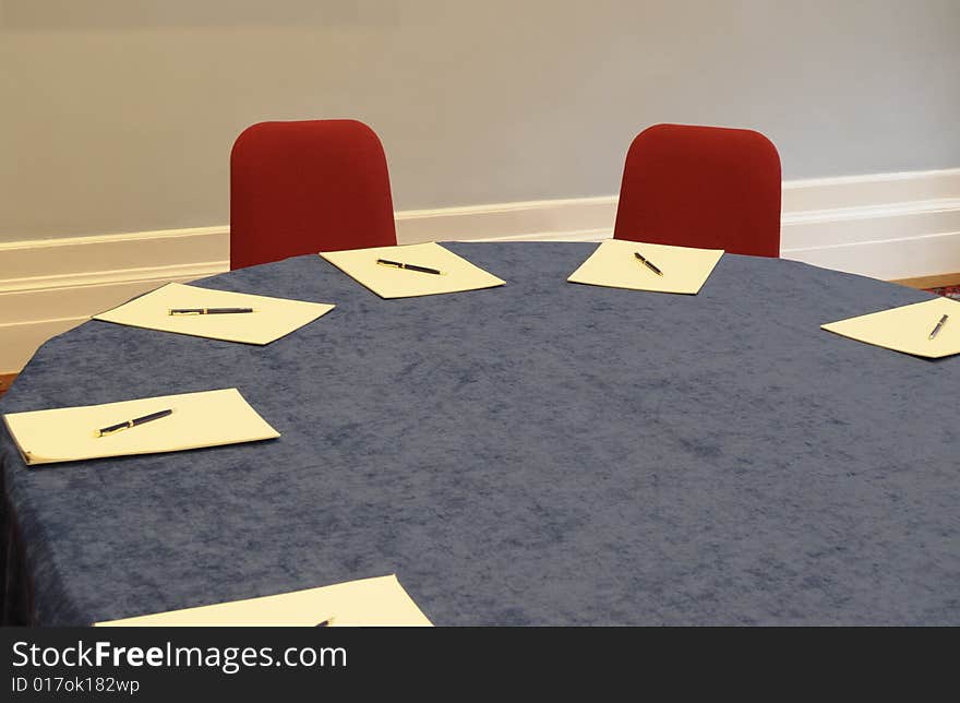 Table prepared for negotiation. Light mixed - lamps and light from a window. Table prepared for negotiation. Light mixed - lamps and light from a window.