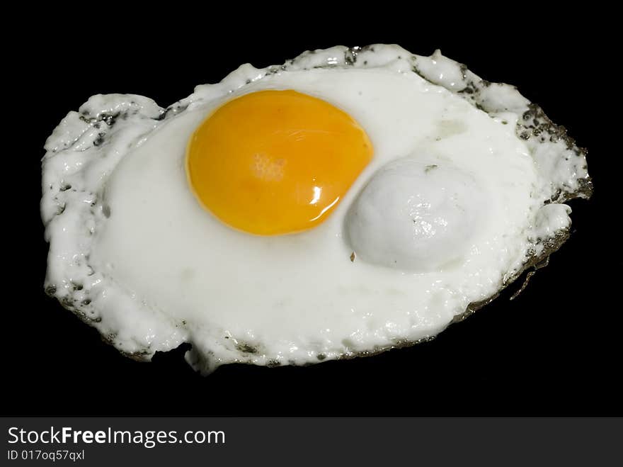 A shot of a fired egg isolated on black. A shot of a fired egg isolated on black