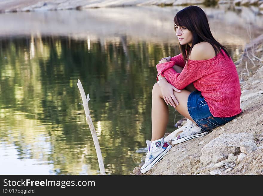 Young beautiful woman relaxing near water. Young beautiful woman relaxing near water.