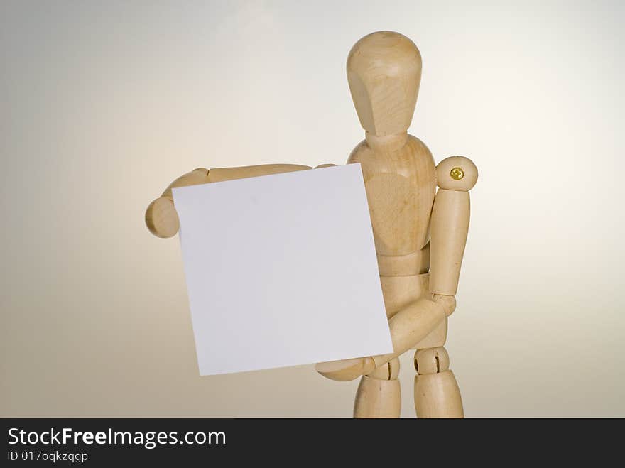 A shot of a wooden doll holding a sign. A shot of a wooden doll holding a sign