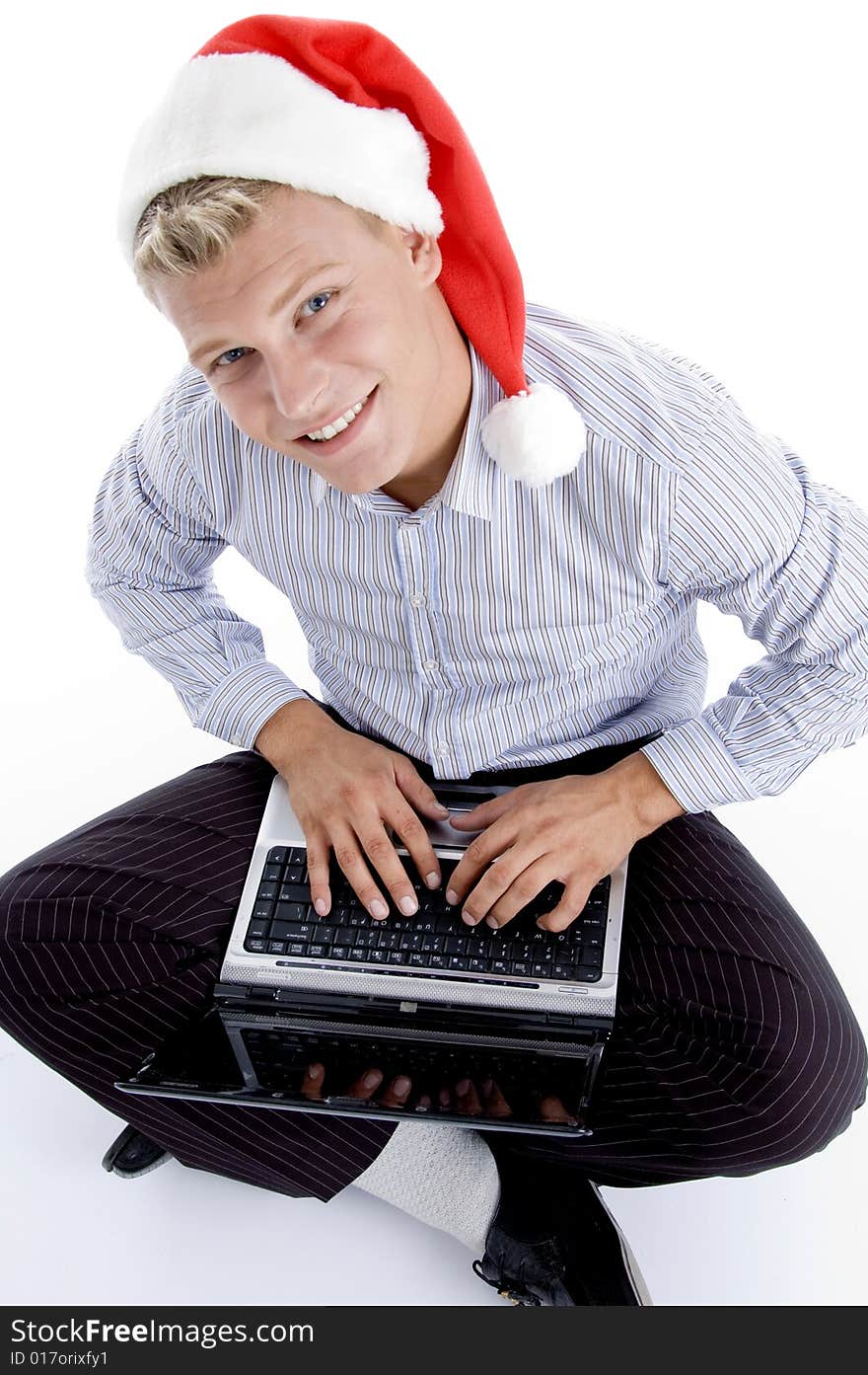 Male working on laptop and looking to camera against white background