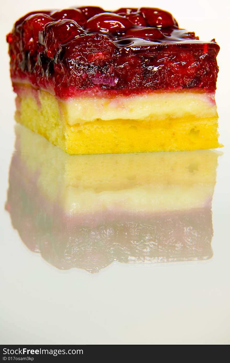 A shot of some rasberry cake on a reflection surface