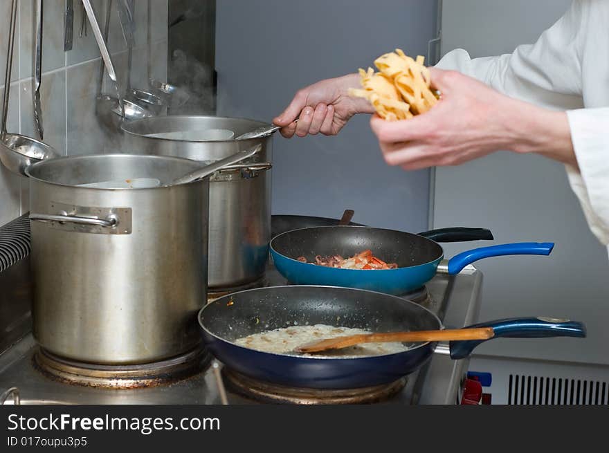 Noodles and sauce preparation, interior of Italian restaurant kitchen. Noodles and sauce preparation, interior of Italian restaurant kitchen