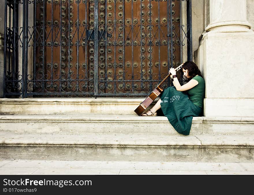 Lone street artist near old church door.