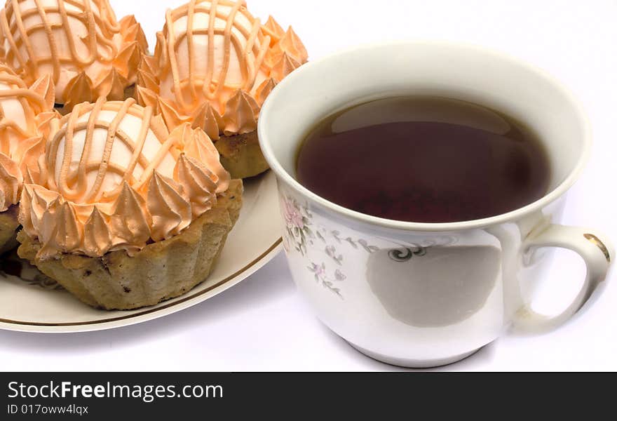 Cup of tea and cakes on a plate on a white background it is isolated