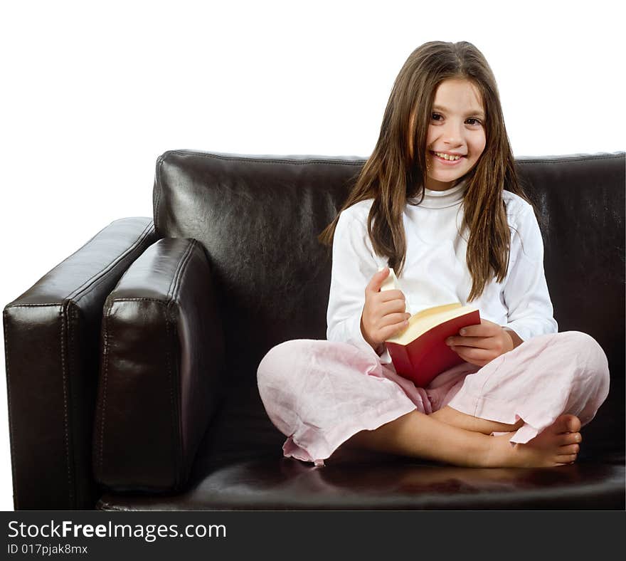 Girl reading a book on a sofa isolated on white