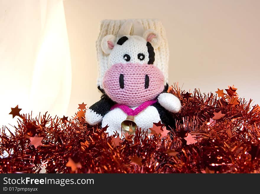 Mitten cow sitting on tinsels. Mitten cow sitting on tinsels