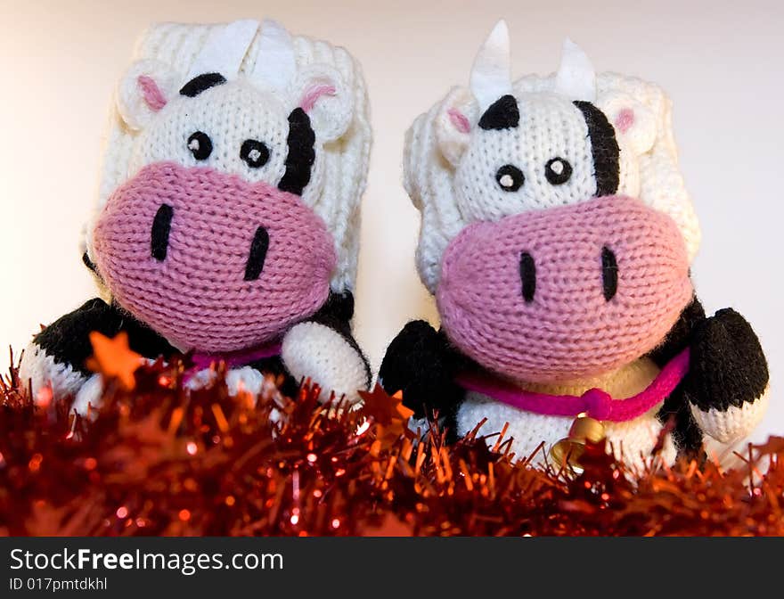 Mitten cows sitting on tinsels. Mitten cows sitting on tinsels