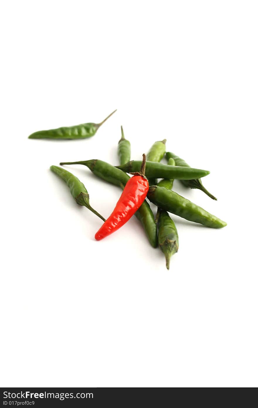 Green and red chilis on a white background