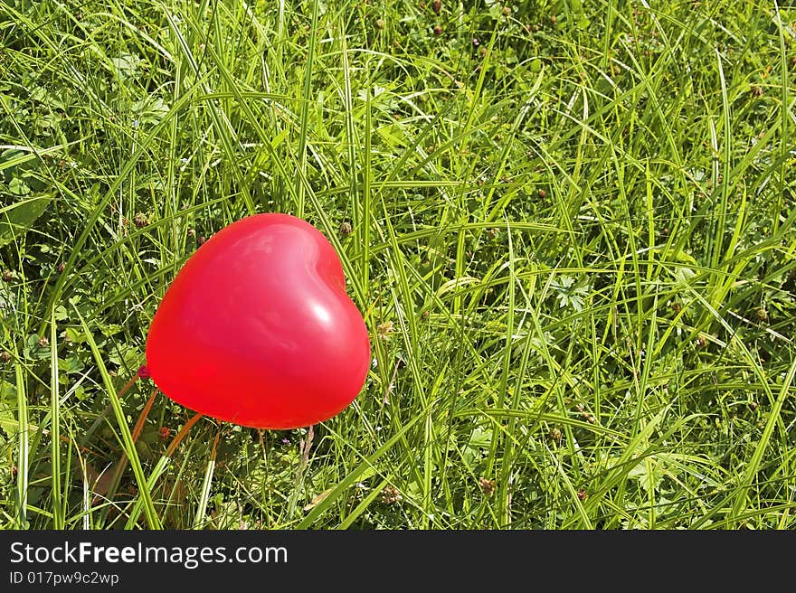 Red balloon in a green grass. Red balloon in a green grass