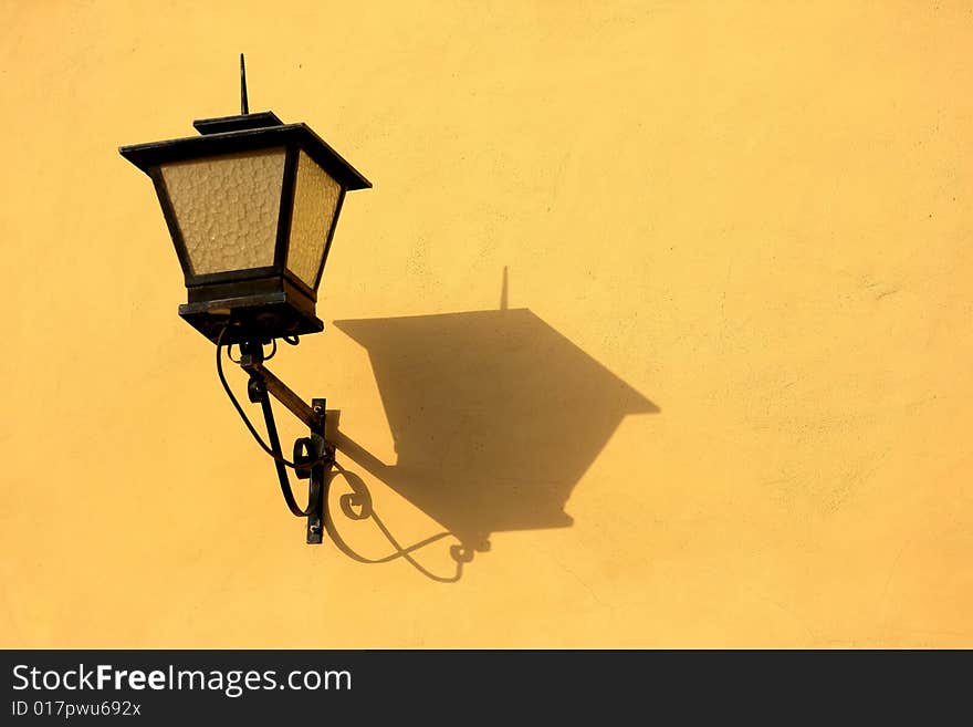 Old street lamp with shade on background wall building. Old street lamp with shade on background wall building