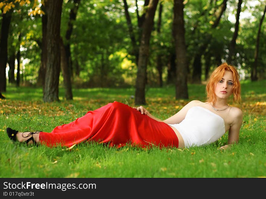 Beautiful young woman in red dress outdoor photo